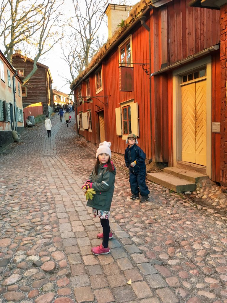 Things to do in Stockholm with kids: Girl walking through Skansen village