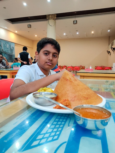 India for kids: boy eating mysore masala dosa