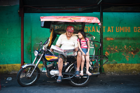 PHILIPPINES: Eighty-three-year-old tricycle driver Demetrio S. Legaspi from Manila reads the paper every day, sometimes with his granddaughter watching. He reads all the newspapers he can get ahold of.