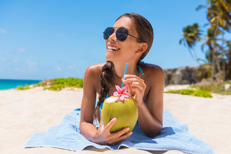 Woman-drinking-coconut-water-having-fun-on-summer-vacation.jpg