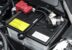 Perrin Performance black battery tie down installed on Subaru car engine