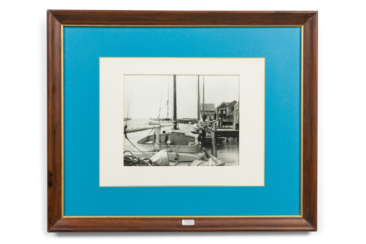 American mid century photograph of a man standing on a boat at the docks