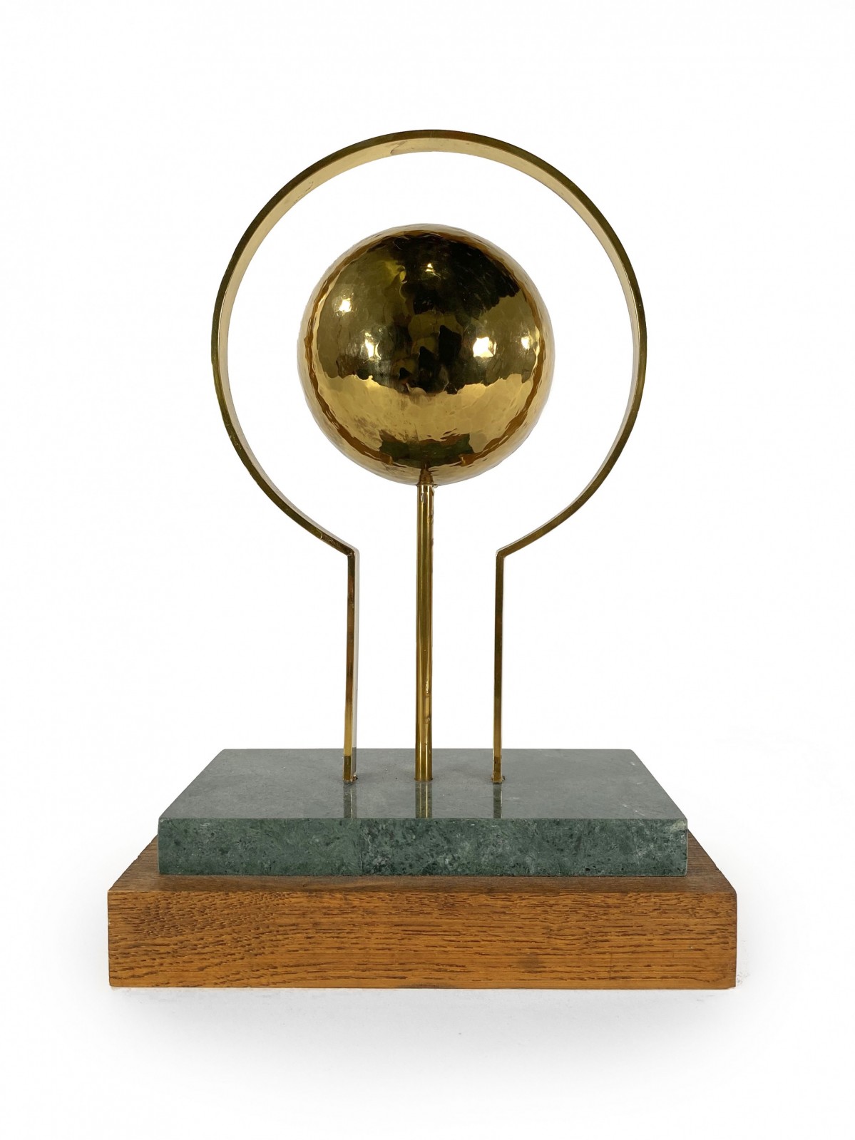 Round sculpture in brass with rectangular base