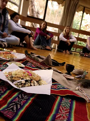 traditional andean despacho ceremony held by paco juan gabriel with coca leaves during women's ayahuasca retreat in the sacred valley cusco peru.
