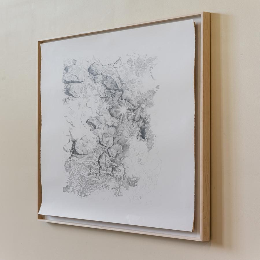 Framed gray textured artwork resembling geological formations.