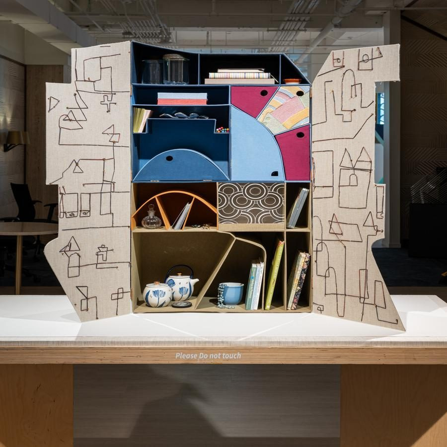 An artistic shelving unit with colorful compartments and abstract line drawings on exterior panels.