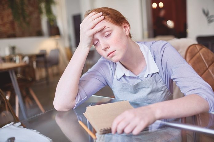 Exhausted Waitress Suffering from Headache