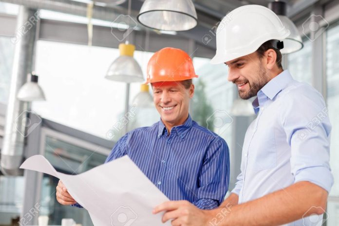 Cheerful male architects are discussing the new project