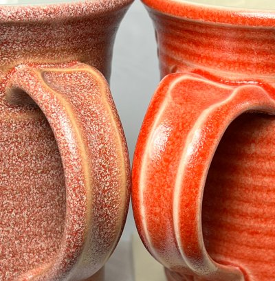 Two marbled bright red coffee mugs