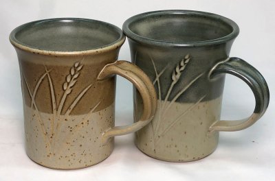 Two mugs. One  fires a rich brown over the black engobe because it has 1% iron added.