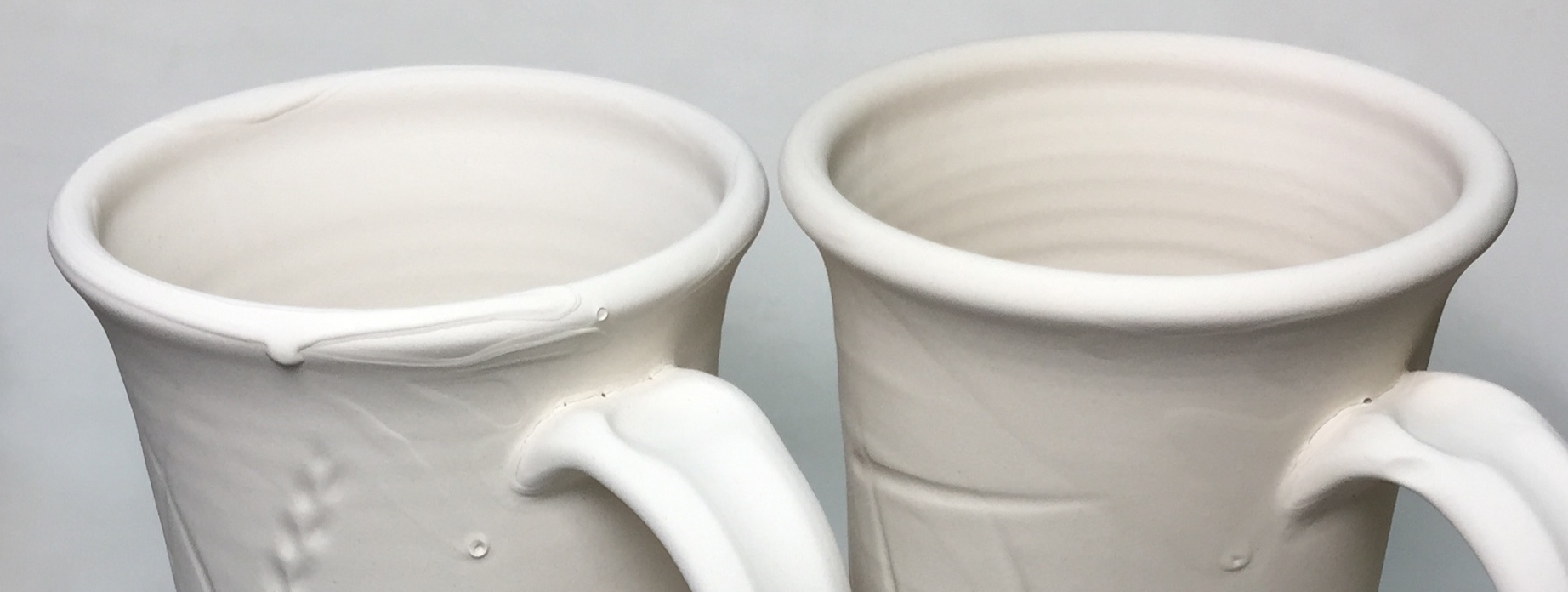 Two mugs, one with glaze drips