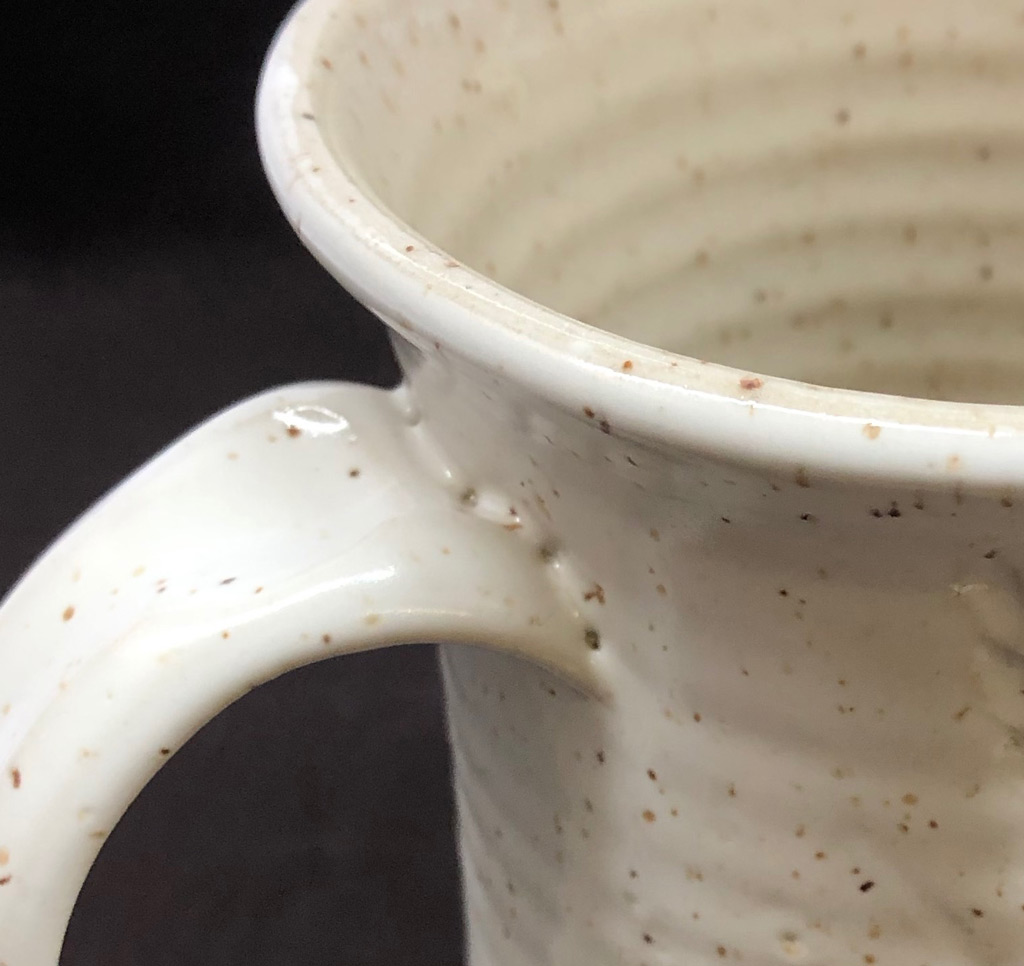 A matte glazed G2934Y mug where the glaze has crawled on the upper handle join