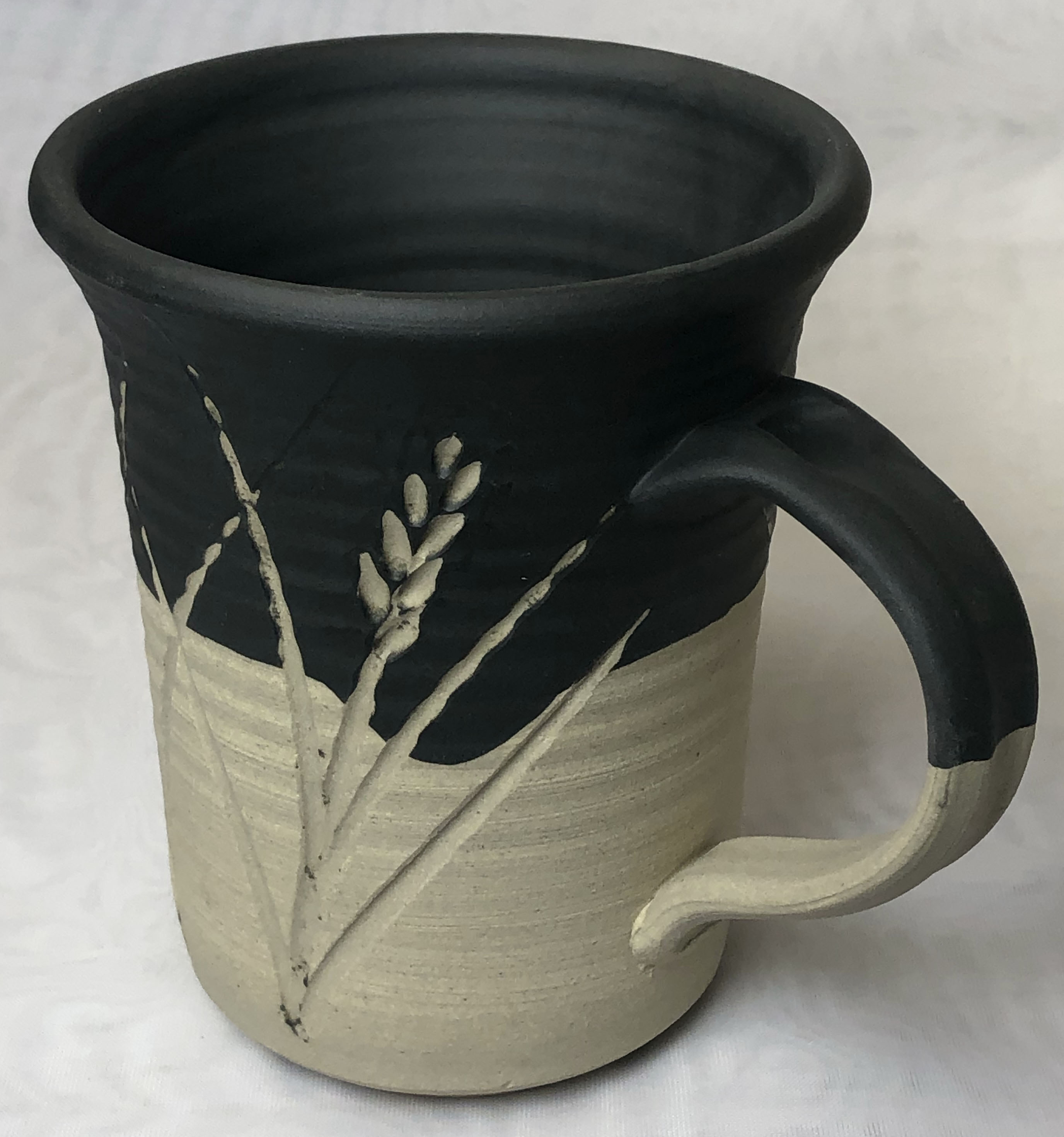 A buff stoneware mug with black engobe