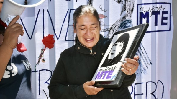 Claudia Carrasco, la madre de Rosa Acuña portando un retrato de suy hija asesinada en el año 2018.