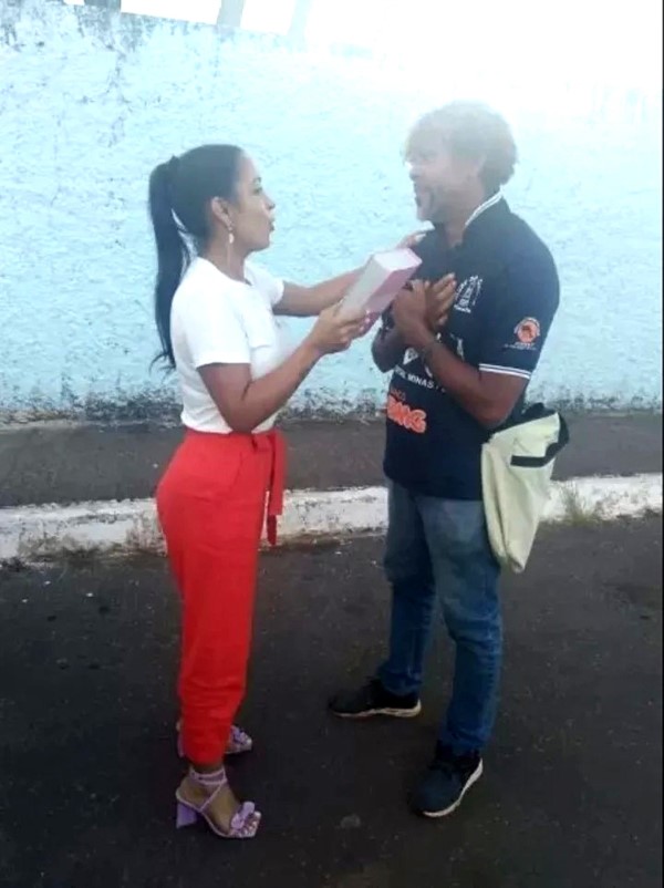 La mujer, de 33 años dandole la palabra de Dios al linyera.