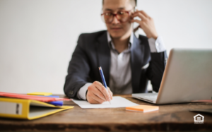 Man at desk on phone prescreening tenant inquiry call.