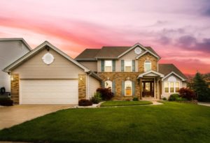 View a Beautiful Home with the Sun Setting Behind It