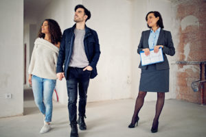 Real estate agent is showing new apartment to a young couple