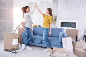 upbeat young female roommates having just successfully moved into their new flat