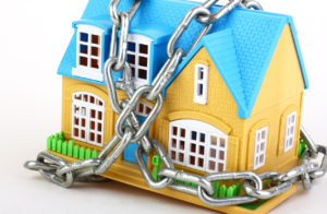 miniature model of a house with heavy metal chains surrounding it