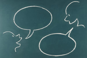 illustration on a chalkboard of two heads talking to one another