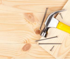 A Hammer and Some Nails on a Hardwood Background