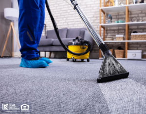 Professional carpet cleaner working in living room of rental property