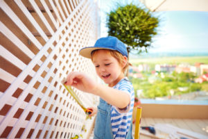 Young Salt Lake City Resident Measuring the Trellis on an Outdoor Patio