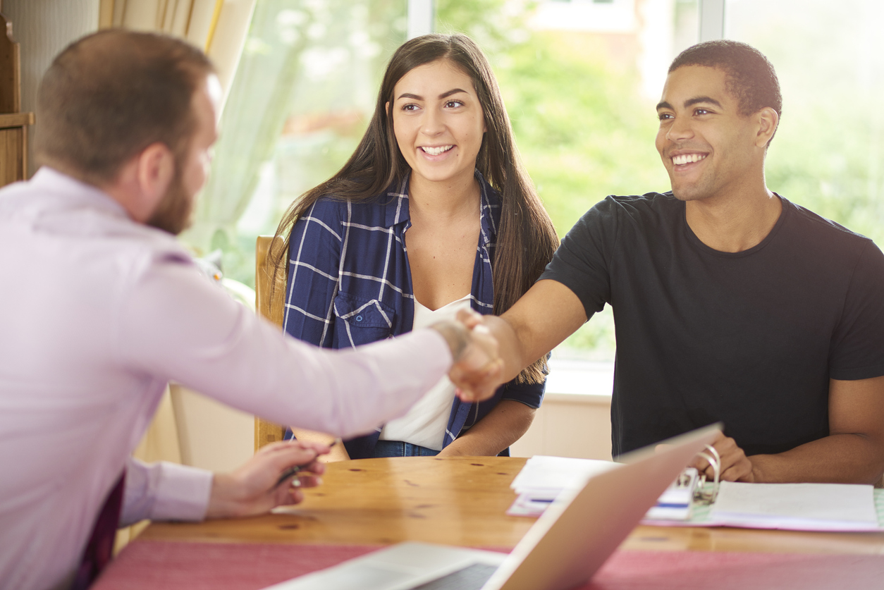 Property manager shaking hands with approved tenants for a Salt Lake City rental property