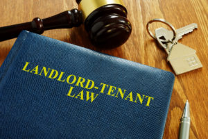 Landlord Tenant Law Book on a Desk with Gavel and House Keys