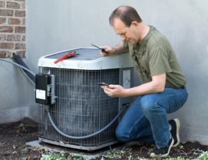 Handyman Repairing an Outdoor Air Conditioning Unit
