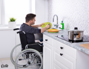 Bullhead City Tenant Cleaning Dishes in the Kitchen from His Wheelchair