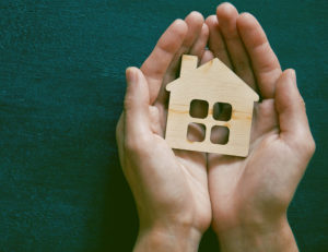 Hands holding house - property management