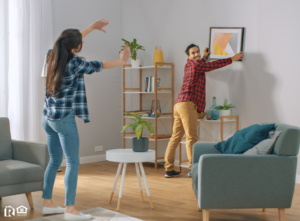 A Couple Hanging Photos on the Wall of Their Mountain House Rental Home