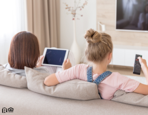 Mother and Daughter Watching Cable TV in Their Humble Rental Home
