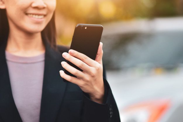Woman holding iPhone looking for top real estate investment apps