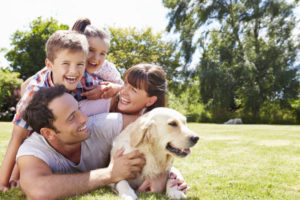 family relaxing in garden with pet dog