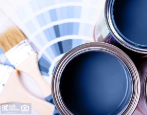 Paint brushes placed on top of can filled with blue paint