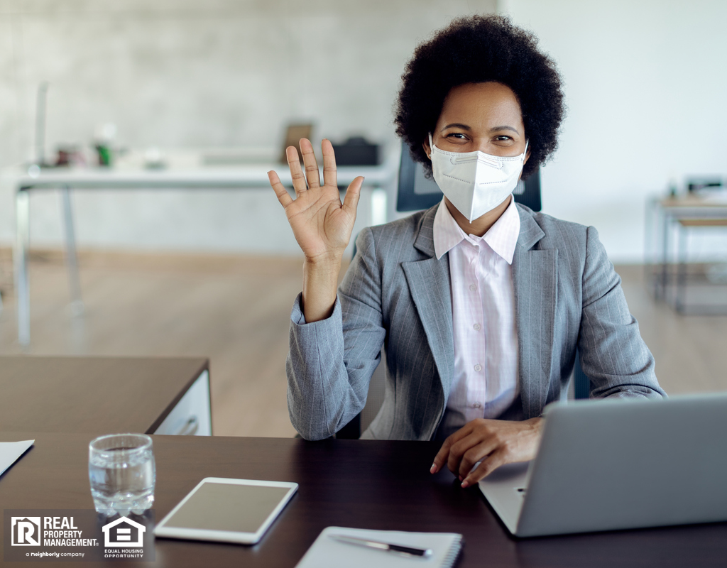 Real Estate Agent Sitting At Desk With Face Mask
