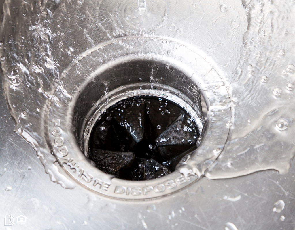 Sink with Water Flowing Down into a Garbage Disposal Real Property