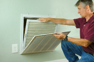 Cottage Grove Homeowner Replacing Air Filter on Their Air Conditioner