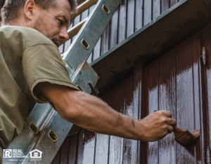 Painter putting second coat on house exterior