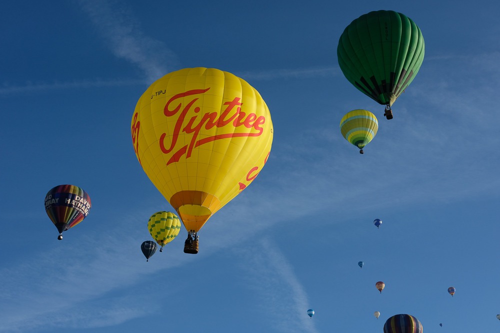 Several hot air balloons including a Tiptree advertising balloon