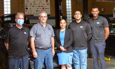 people standing in front of an auto bay