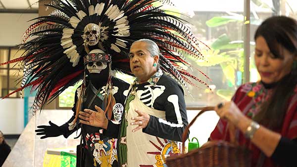 Man speaking at Dia de los Muertos event