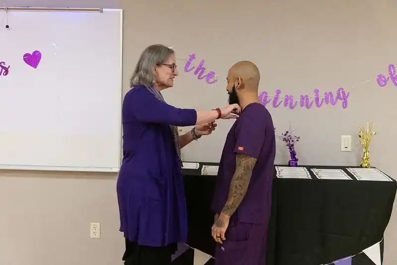a woman putting a pin on a man