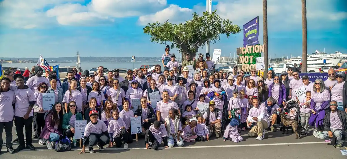 a group of people in pink t-shirts some holding picket signs