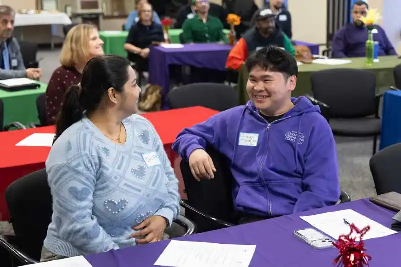 a woman and a man at a desk talking