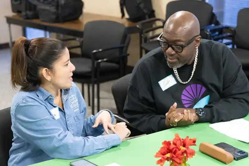 a woman and a man at a desk talking