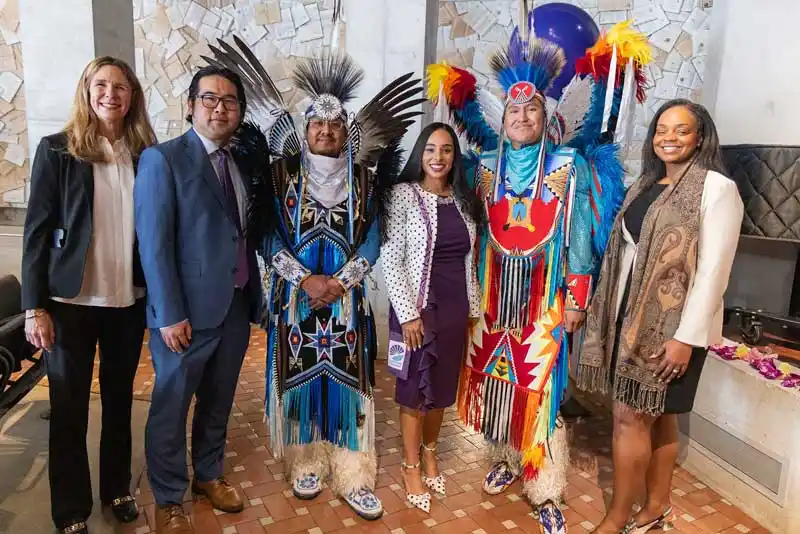 a group of people including 2 in traditional native american clothing
